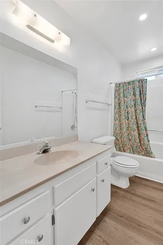a bathroom with a granite countertop sink toilet a mirror and shower
