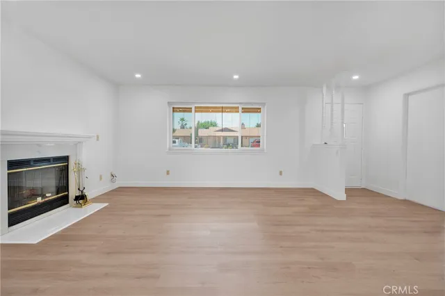 a view of an empty room with a window and fireplace