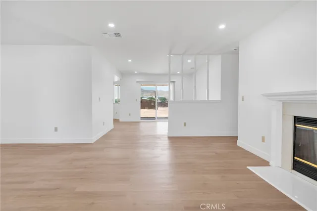 an empty room with wooden floor and fireplace