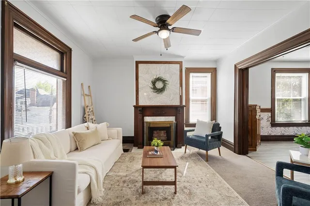 a living room with furniture a fireplace and a large window