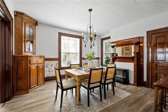 a dining room with furniture a chandelier and wooden floor