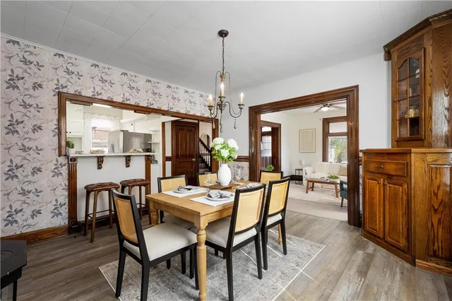 a dining room with furniture a chandelier and wooden floor
