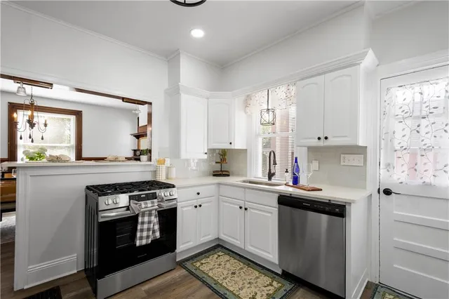 a kitchen with stainless steel appliances a sink stove and cabinets