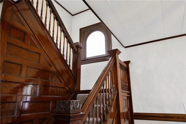 a view of staircase with railing and white walls