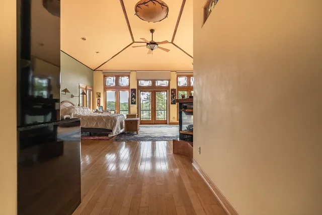 a bed sitting in a spacious bedroom next to a large window