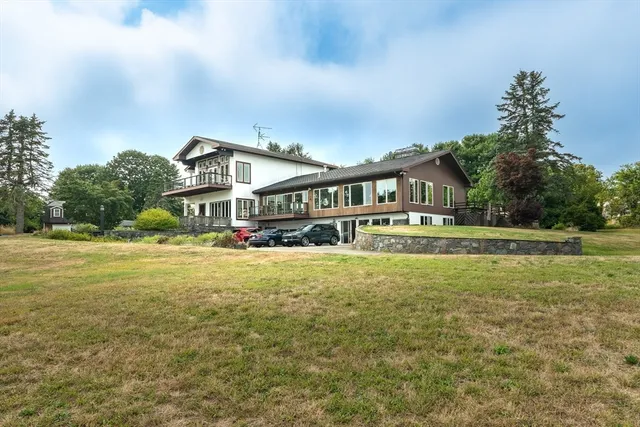 a front view of a house with a yard and trees