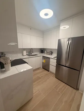 a kitchen with stainless steel appliances granite countertop a refrigerator sink stove and refrigerator