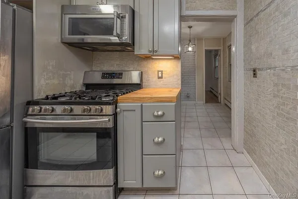 a kitchen with cabinets and steel stove top oven