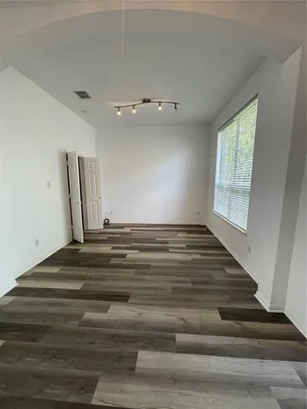 a view of empty room with window and wooden floor
