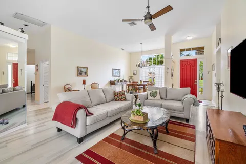 a living room with furniture kitchen view and a flat screen tv