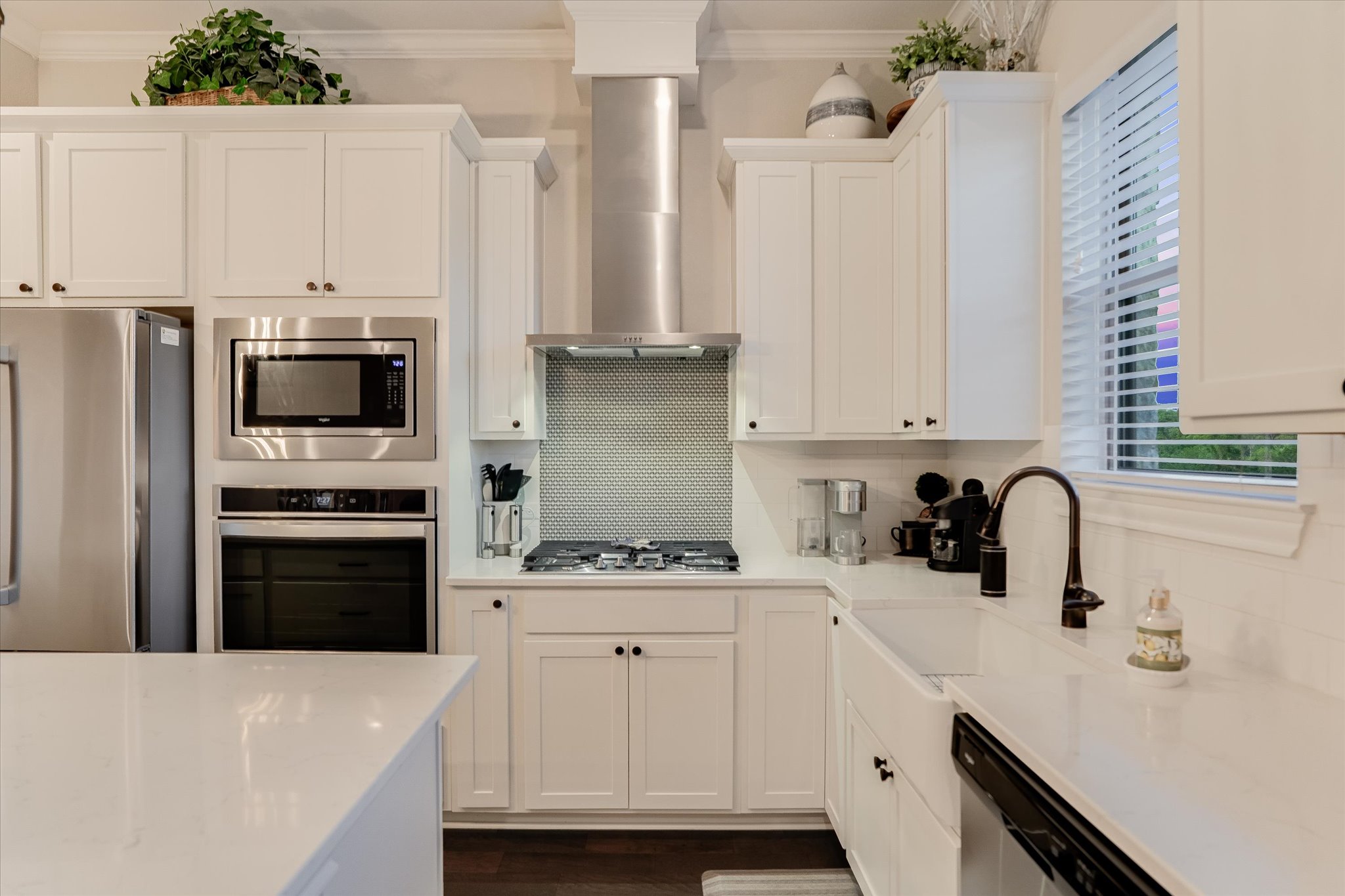 309 Adams Street Georgetown, TX 78628 - Photo 11 of 30 Kitchen featuring stainless steel appliances, white cabinets, crown molding, light stone countertops, and dark wood finished floors