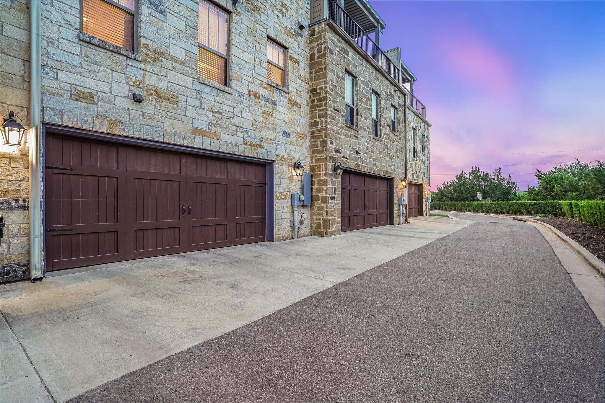 309 Adams Street Georgetown, TX 78628 - Photo 26 of 30 Property exterior at dusk with stone siding, concrete driveway, and an attached garage