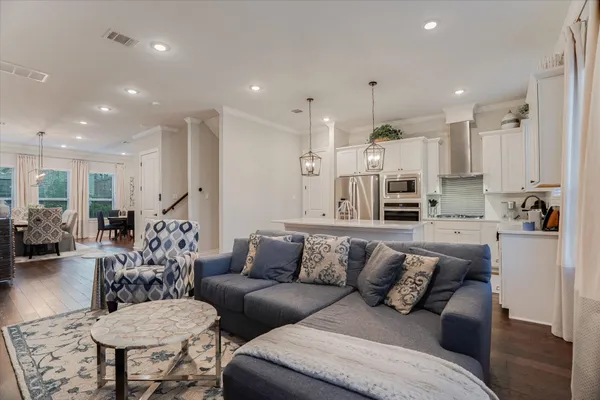 a living room with furniture kitchen and a chandelier