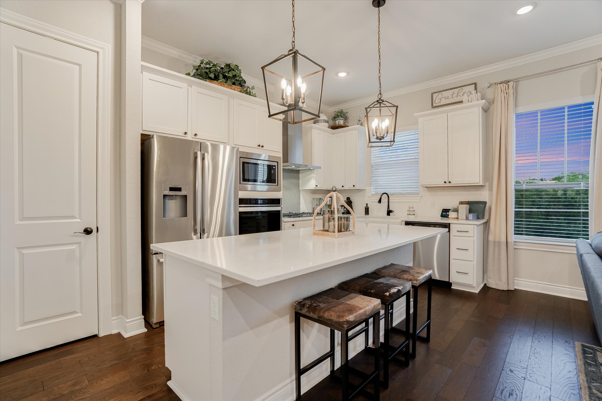 309 Adams Street Georgetown, TX 78628 - Photo 10 of 30 Kitchen featuring white cabinets, dark wood-style floors, stainless steel appliances, an island with sink, and a breakfast bar