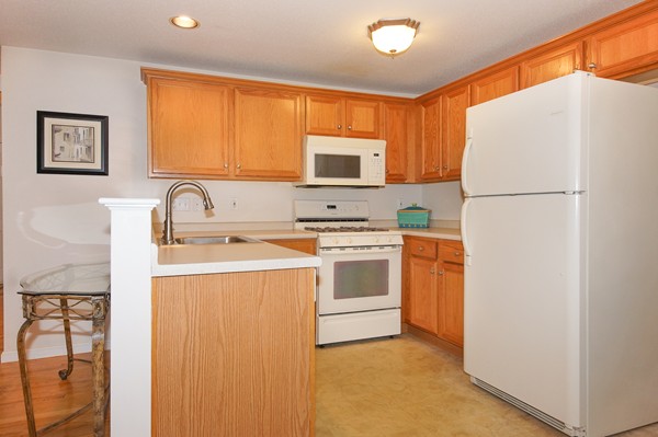 53 Lancaster Road, Unit 10 Clinton, MA 01510 - Photo 4 of 20 a kitchen with white cabinets and white appliances