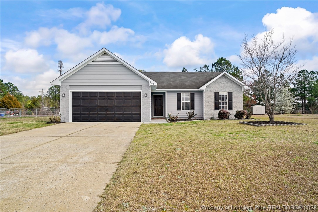 149 Cavalier Drive Raeford, NC 28376 - Photo 1 of 31 a front view of a house with a garden and trees