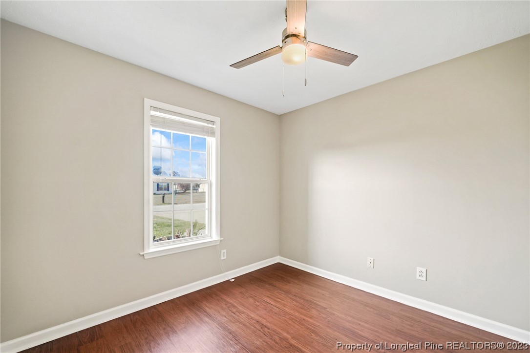 149 Cavalier Drive Raeford, NC 28376 - Photo 22 of 31 an empty room with wooden floor chandelier and windows