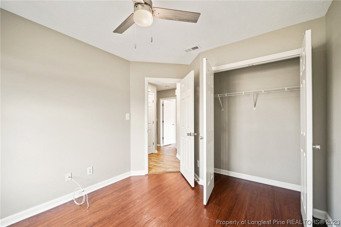 149 Cavalier Drive Raeford, NC 28376 - Photo 23 of 31 an empty room with wooden floor and a ceiling fan