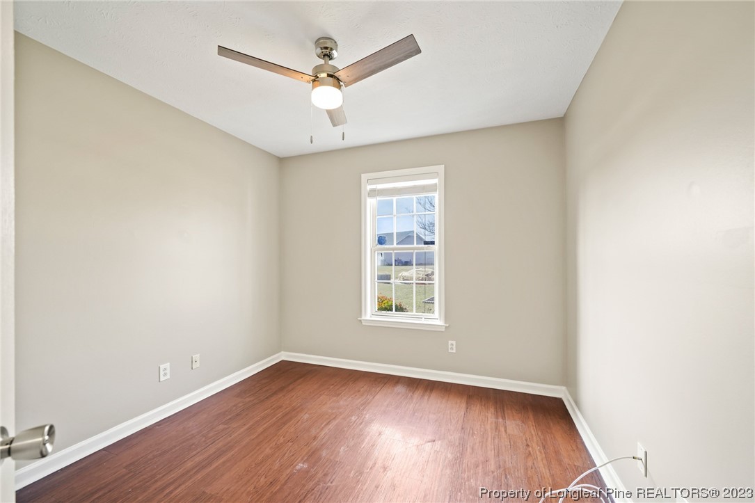 149 Cavalier Drive Raeford, NC 28376 - Photo 24 of 31 an empty room with wooden floor ceiling fan and window