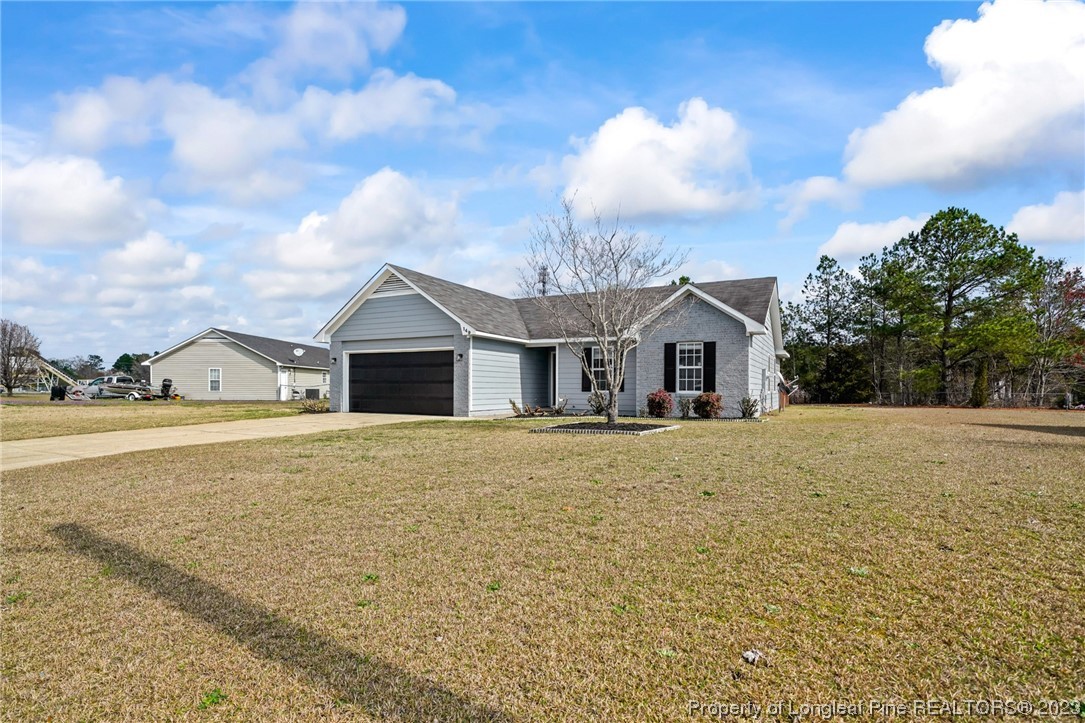 149 Cavalier Drive Raeford, NC 28376 - Photo 3 of 31 a front view of a house with a yard and garage