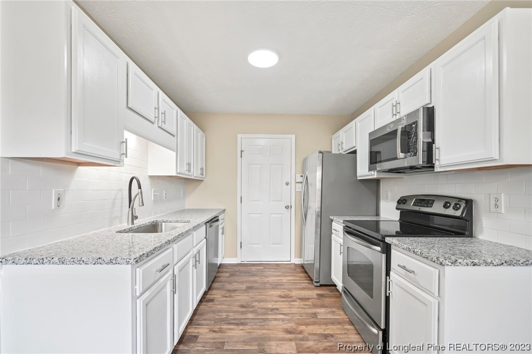 149 Cavalier Drive Raeford, NC 28376 - Photo 10 of 31 a kitchen with stainless steel appliances granite countertop a sink stove and refrigerator