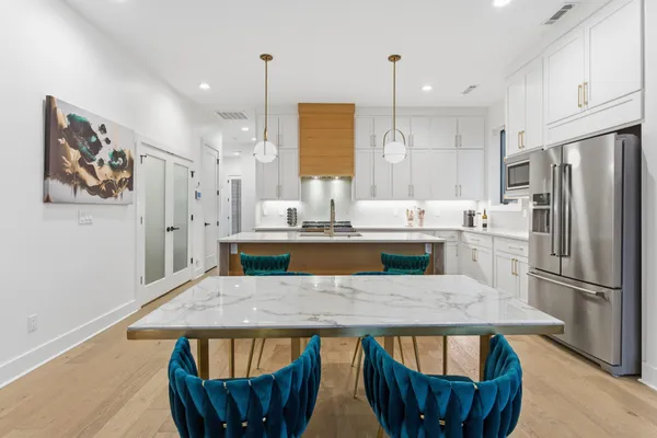 a kitchen with stainless steel appliances granite countertop a kitchen island a refrigerator a stove and a sink