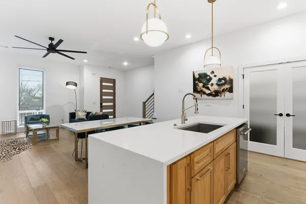 a kitchen that has a lot of cabinets a sink and a wooden floor