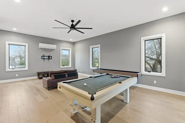 a living room with pool table and windows