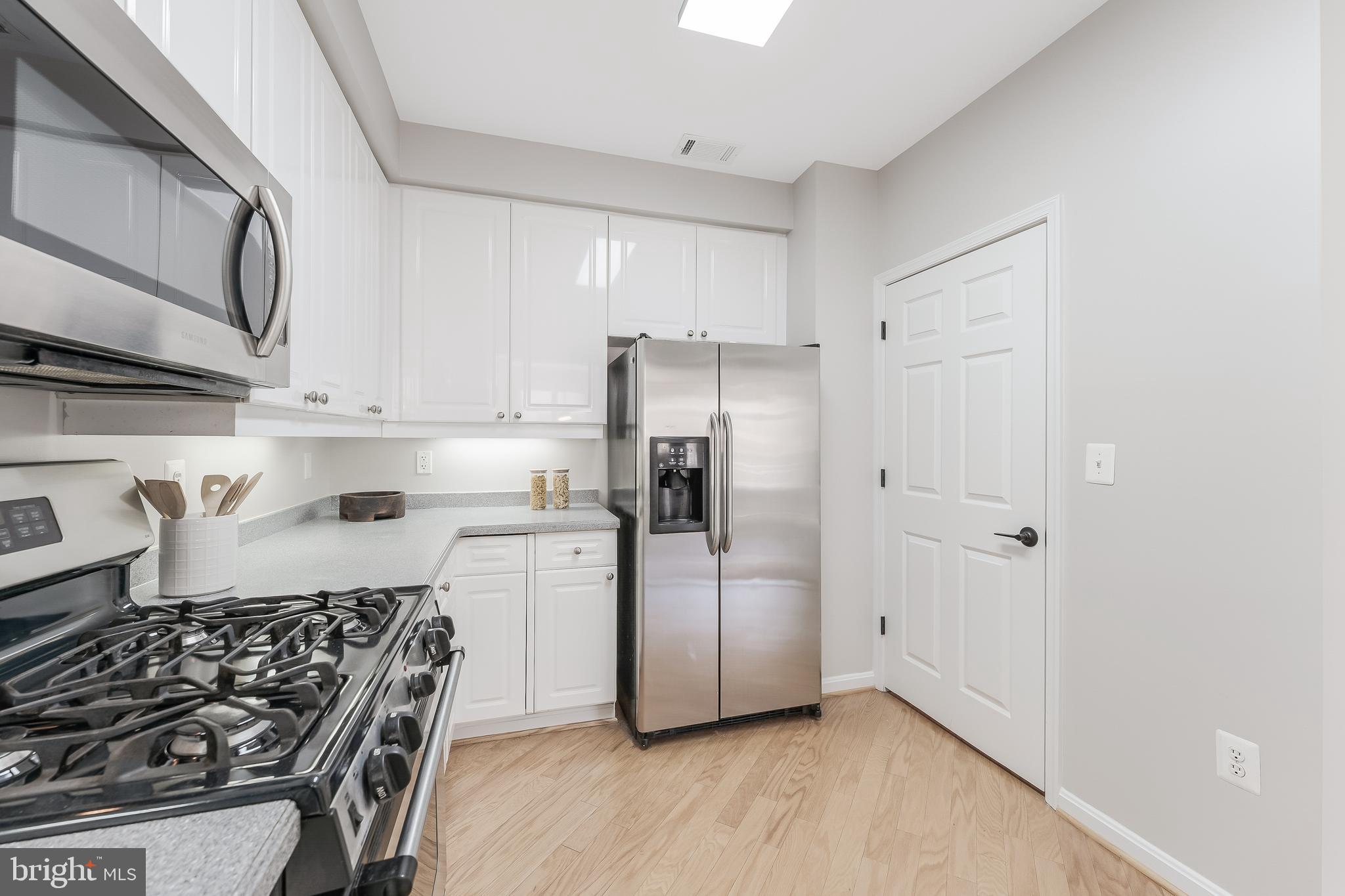 1851 Stratford Park Place, Unit 212 Reston, VA 20190 - Photo 12 of 45 a kitchen with stainless steel appliances granite countertop a refrigerator and a stove top oven