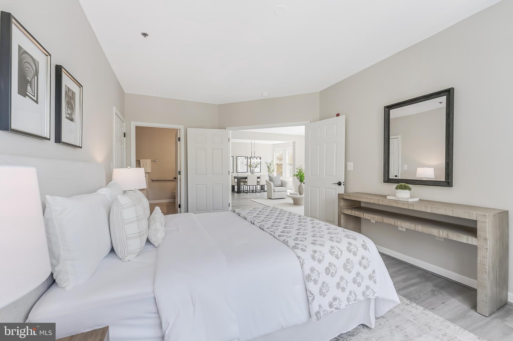 1851 Stratford Park Place, Unit 212 Reston, VA 20190 - Photo 28 of 45 a bedroom with a bed and a large mirror