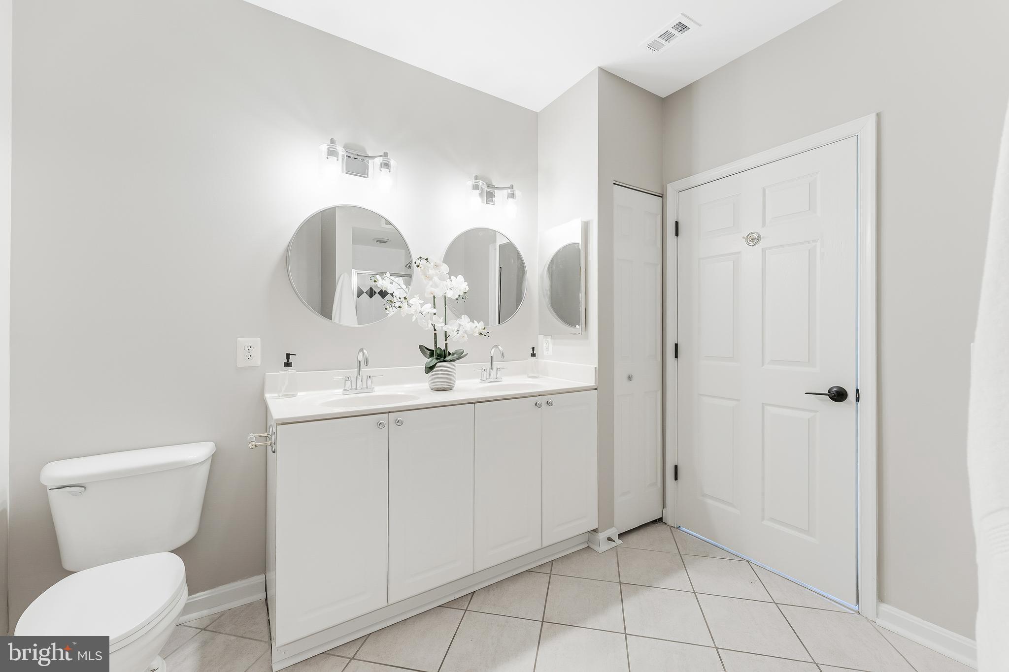 1851 Stratford Park Place, Unit 212 Reston, VA 20190 - Photo 35 of 45 a bathroom with a toilet sink and mirror