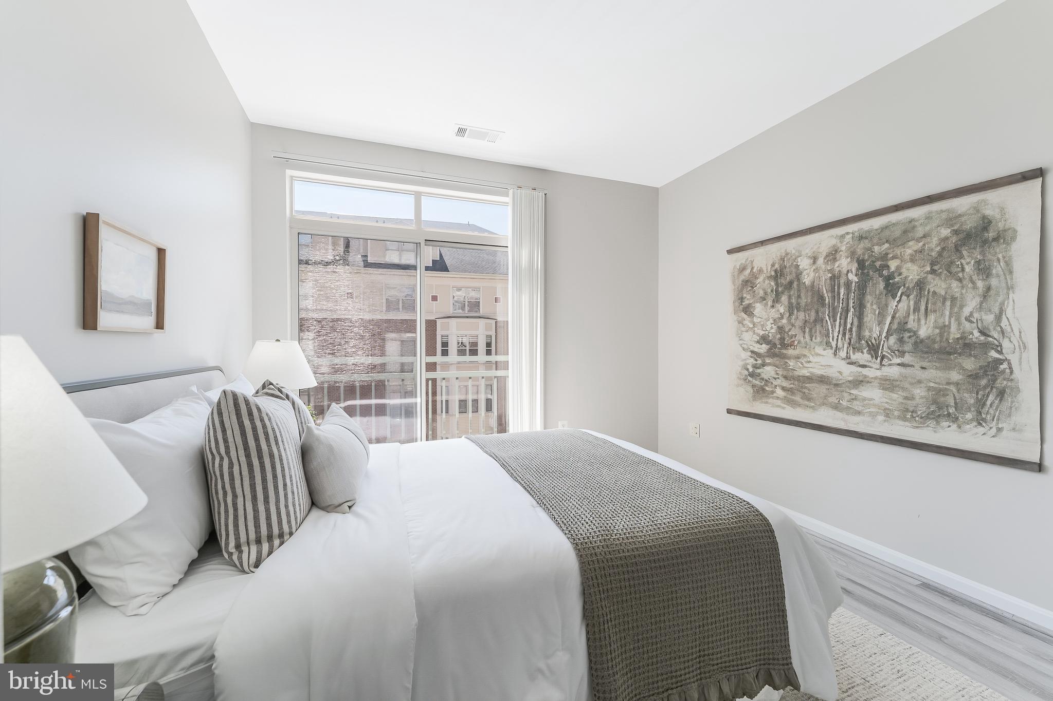 1851 Stratford Park Place, Unit 212 Reston, VA 20190 - Photo 36 of 45 a bedroom with a bed a couch and a window