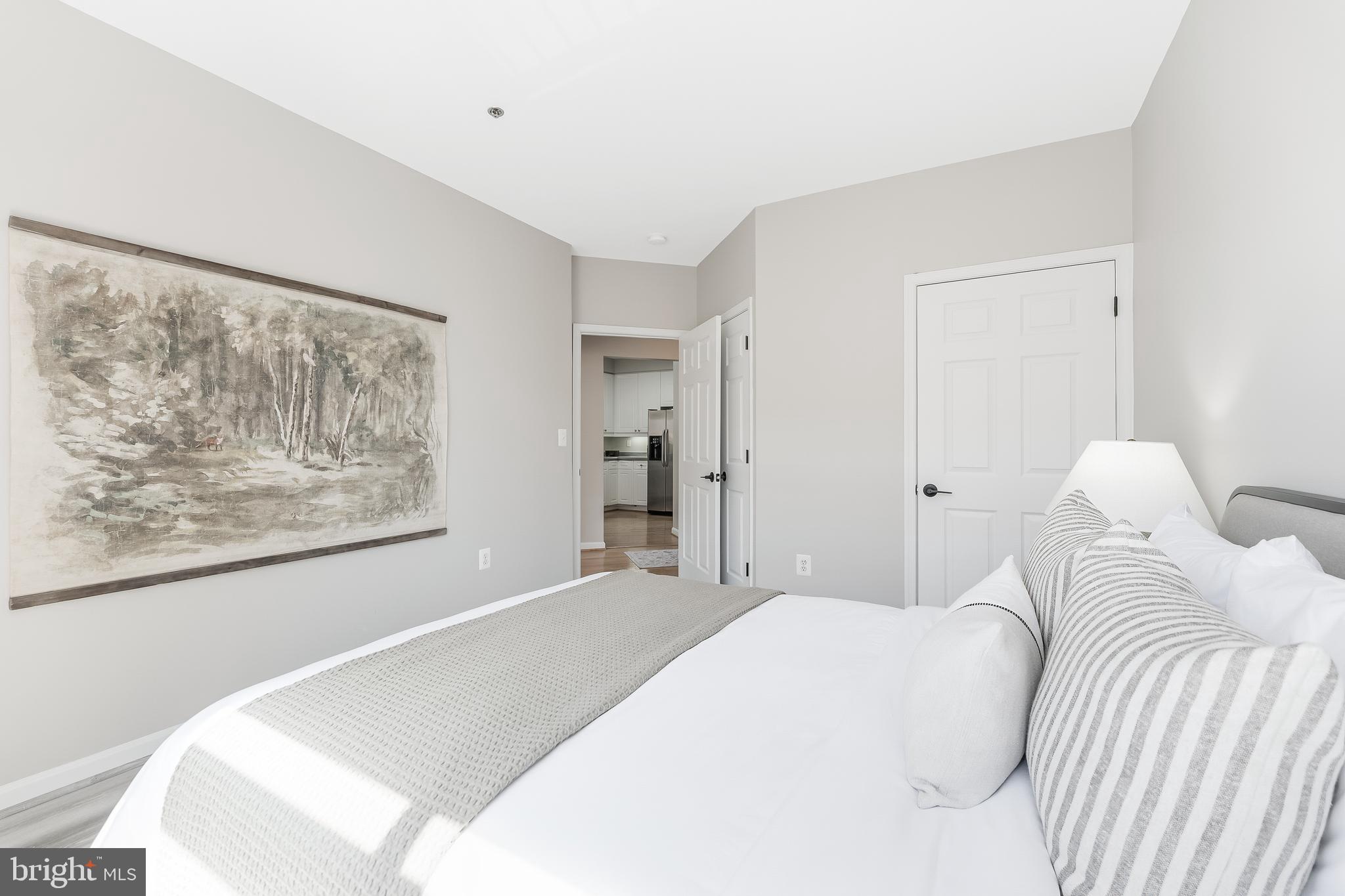 1851 Stratford Park Place, Unit 212 Reston, VA 20190 - Photo 39 of 45 a bedroom with a bed and a painting on the wall