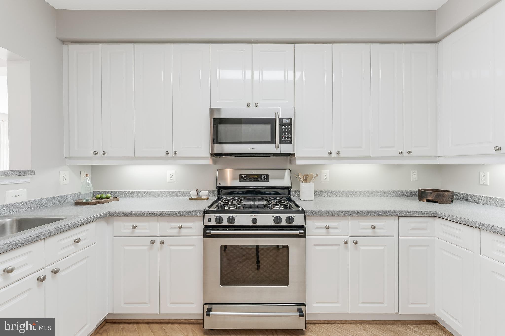 1851 Stratford Park Place, Unit 212 Reston, VA 20190 - Photo 9 of 45 a kitchen with granite countertop white cabinets and stainless steel appliances