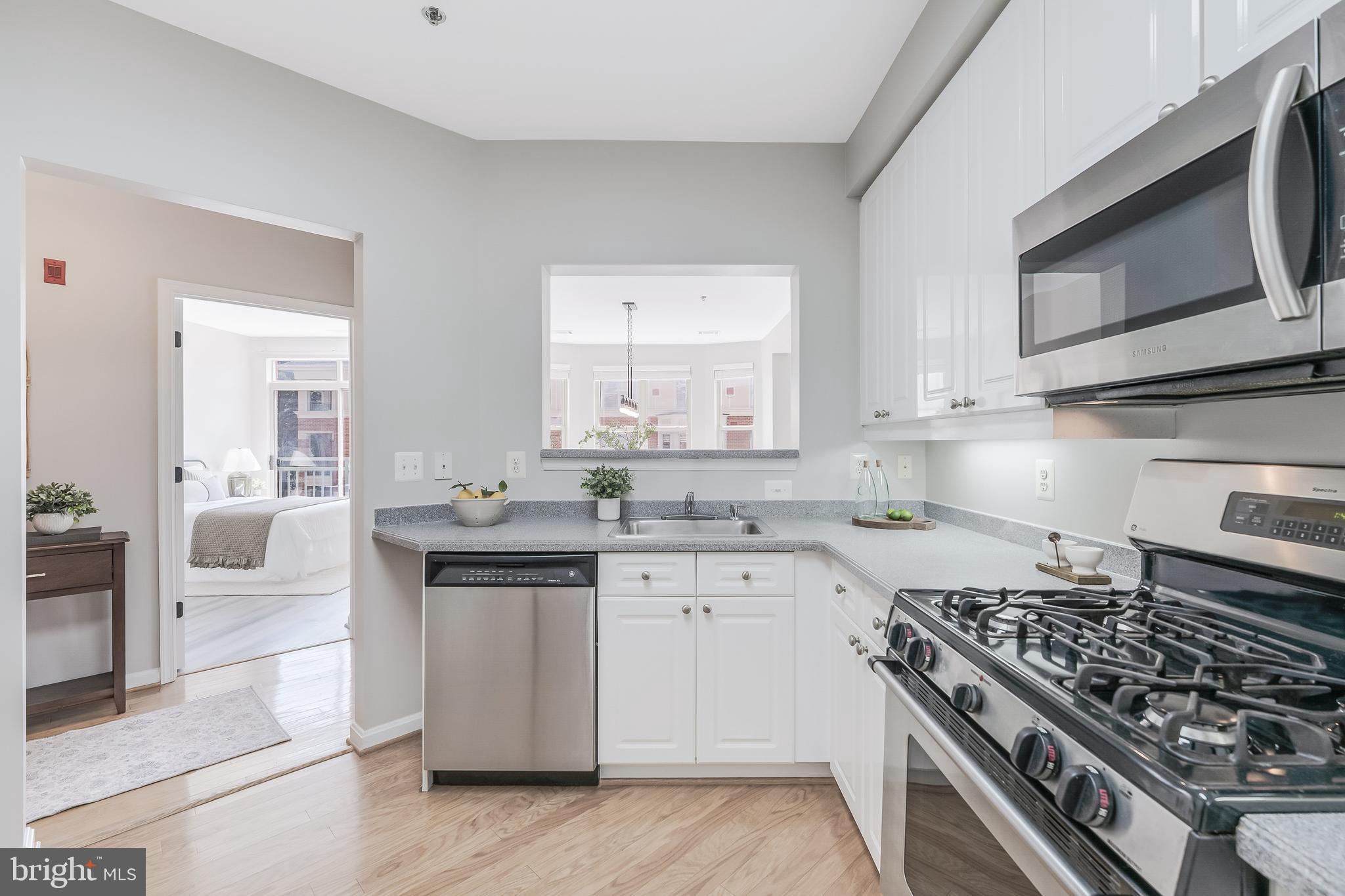 1851 Stratford Park Place, Unit 212 Reston, VA 20190 - Photo 10 of 45 a kitchen with stainless steel appliances a sink stove and cabinets