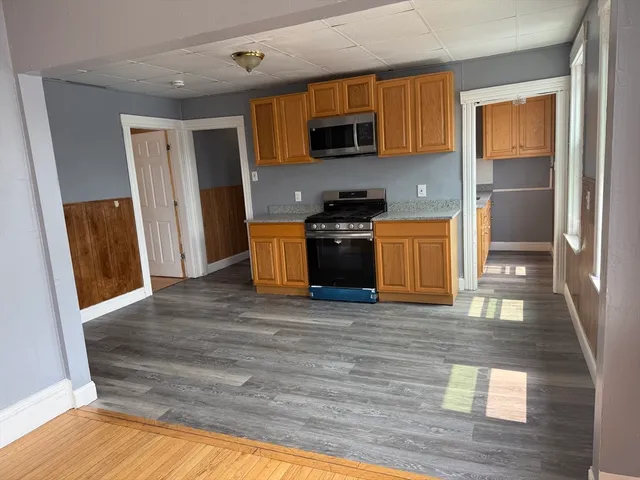 a kitchen with stainless steel appliances granite countertop a refrigerator stove top oven and sink