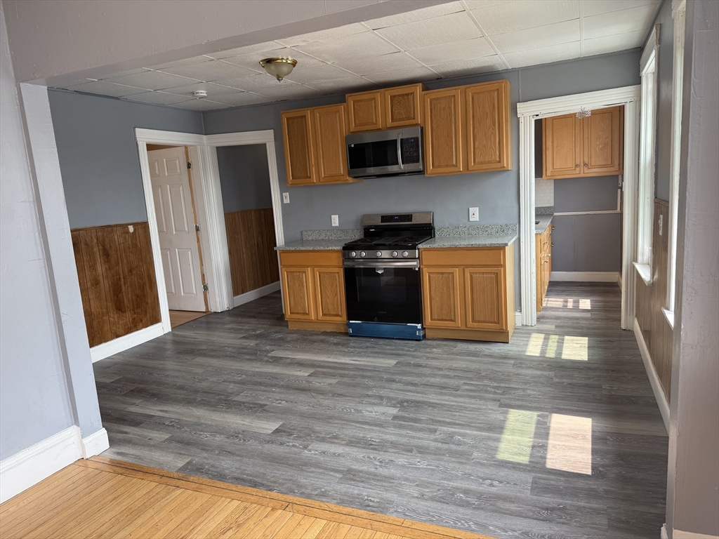 a kitchen with stainless steel appliances granite countertop a refrigerator stove top oven and sink