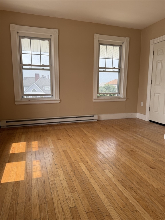 157 Vernon Street, Unit 3 Worcester, MA 01610 - Photo 12 of 15 a view of an empty room with wooden floor and a window