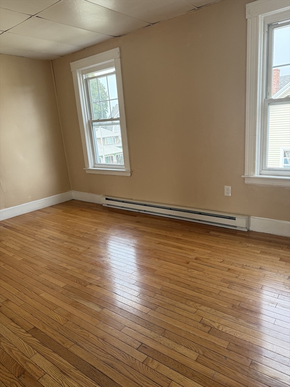 157 Vernon Street, Unit 3 Worcester, MA 01610 - Photo 13 of 15 an empty room with wooden floor and windows