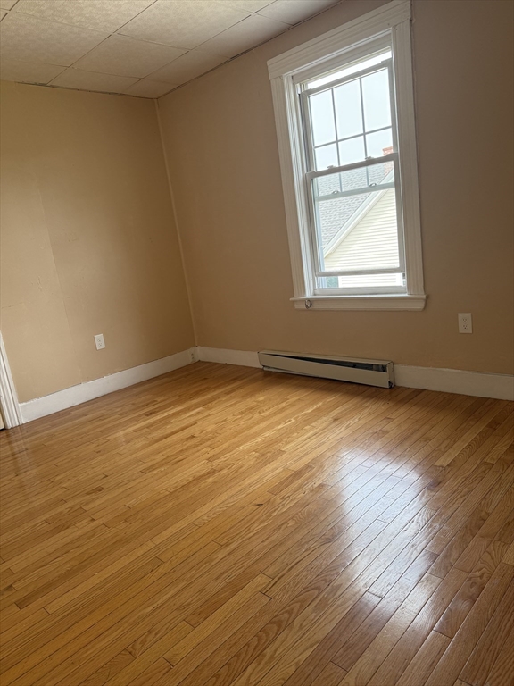 157 Vernon Street, Unit 3 Worcester, MA 01610 - Photo 14 of 15 an empty room with wooden floor and windows