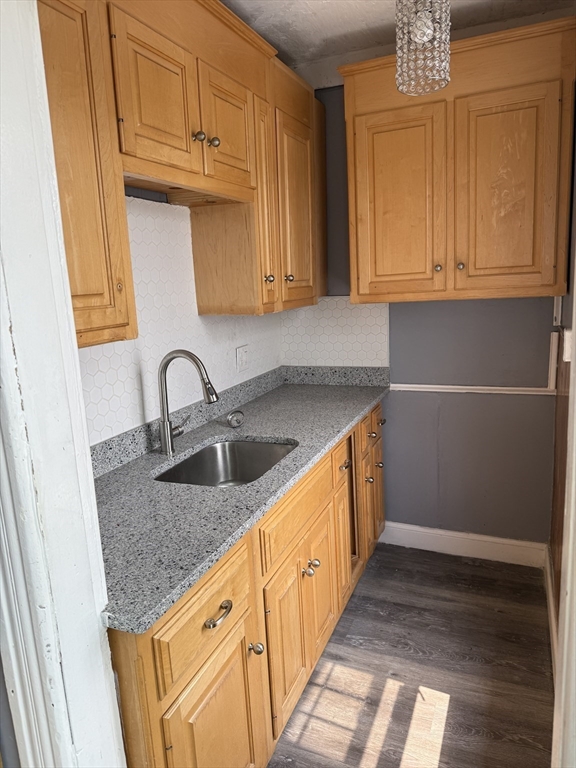 157 Vernon Street, Unit 3 Worcester, MA 01610 - Photo 5 of 15 a kitchen with stainless steel appliances granite countertop a sink dishwasher and cabinets with wooden floor