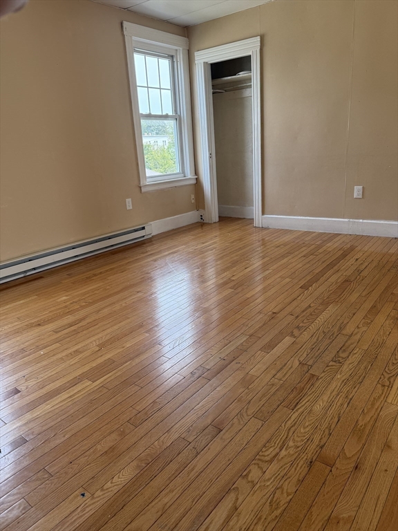 157 Vernon Street, Unit 3 Worcester, MA 01610 - Photo 10 of 15 an empty room with wooden floor and windows