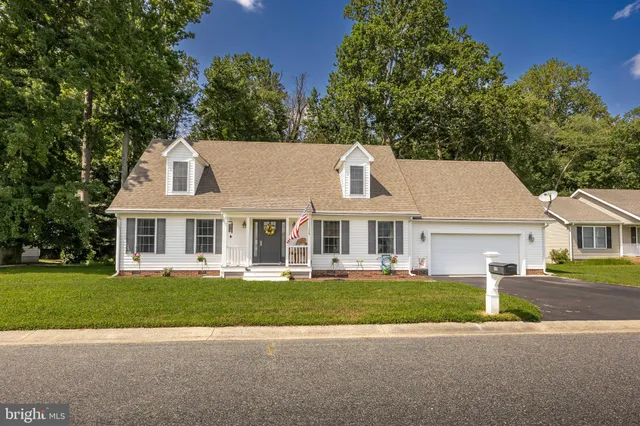 a front view of a house with a garden and trees