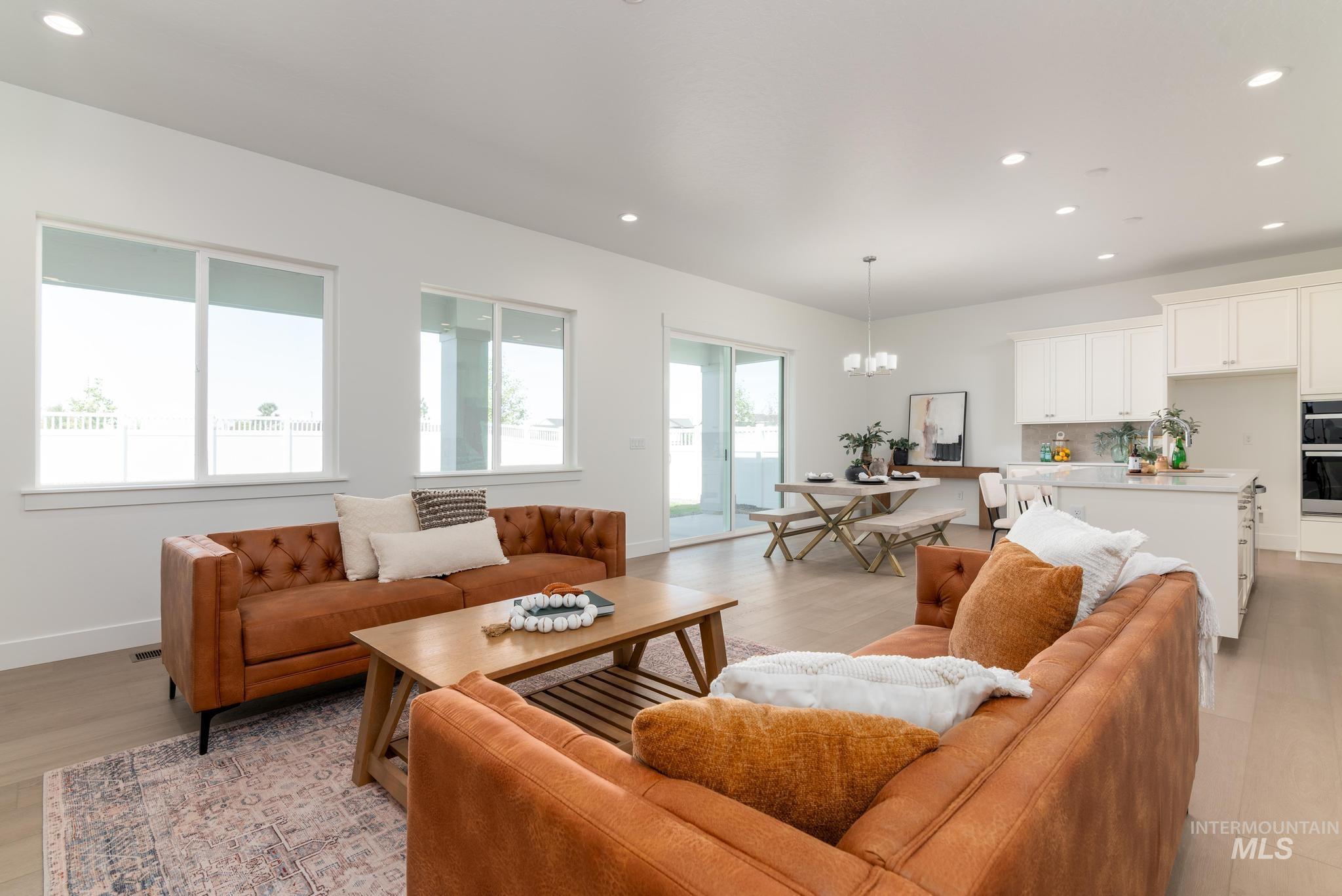 8501 South Country Wind Avenue Meridian, ID 83642 - Photo 6 of 39 Open-concept living space featuring wood-finish flooring, recessed lighting, and large windows