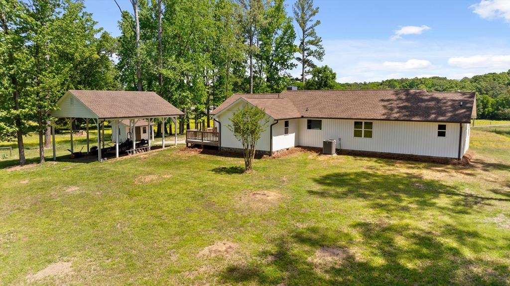 446 Brown Bridge Road Chatsworth, GA 30705 - Photo 23 of 75 a view of a house with pool and chairs under an umbrella