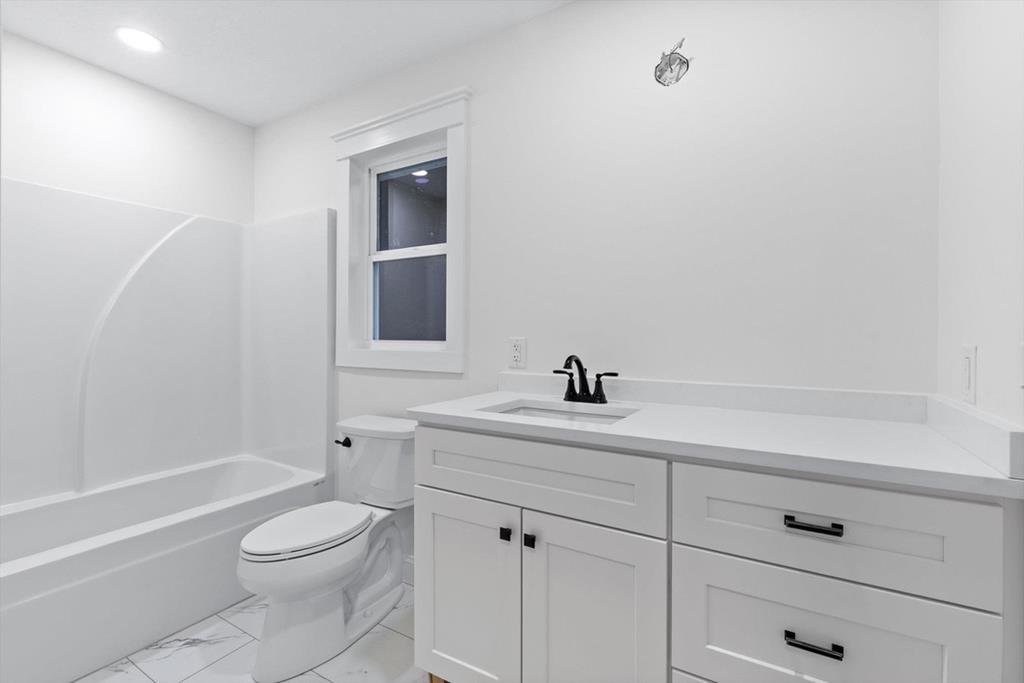 446 Brown Bridge Road Chatsworth, GA 30705 - Photo 63 of 75 a bathroom with a toilet a sink a mirror and vanity