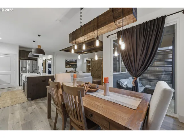 a kitchen with stainless steel appliances kitchen island granite countertop a table chairs and a refrigerator