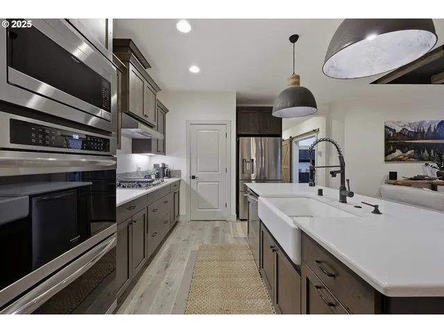 a kitchen with kitchen island granite countertop a sink stainless steel appliances and cabinets