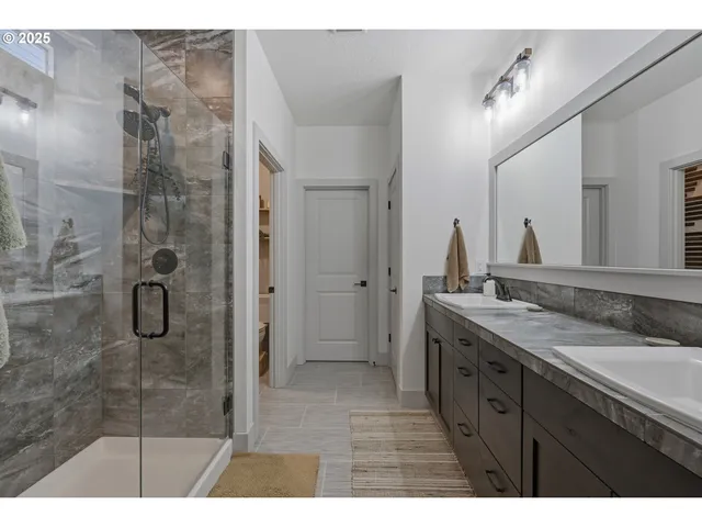 a bathroom with a granite countertop sink mirror shower and