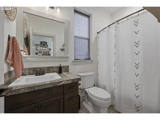 a bathroom with a granite countertop sink toilet a mirror and shower